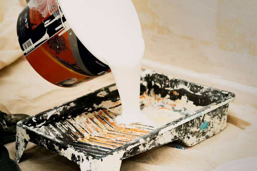Professional painter in Singapore working on a residential wall using high-quality tools and paint for a flawless finish